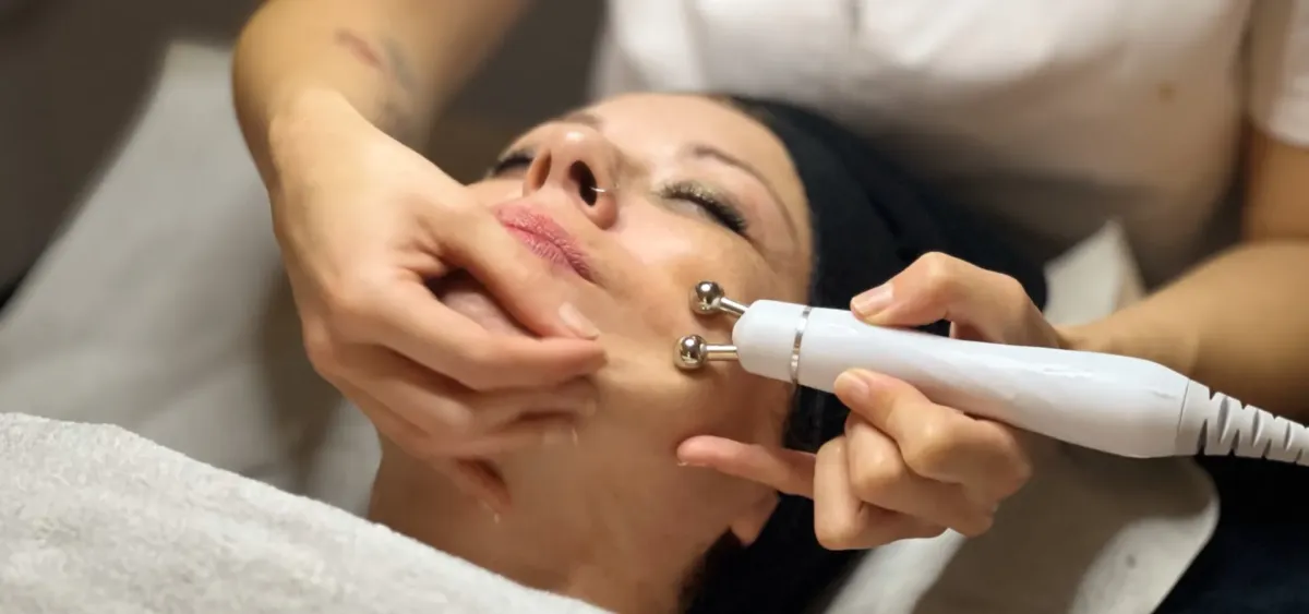 Clienta recibiendo un tratamiento facial con un masajeador